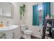 Cozy bathroom with pedestal sink, dark wood accents, and a window providing natural light at 314 Savannah Pl, Loganville, GA 30052
