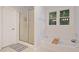 Bathtub with window and glass shower door at 314 Savannah Pl, Loganville, GA 30052