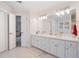 Bathroom with double sinks, white cabinets, and tile floors at 314 Savannah Pl, Loganville, GA 30052