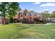 Charming two-story brick home with a lush green lawn and mature trees at 314 Savannah Pl, Loganville, GA 30052