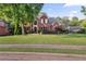 Charming two-story brick home with a lush green lawn and mature trees at 314 Savannah Pl, Loganville, GA 30052