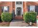 Close-up of the front door with a welcoming wreath, flanked by manicured bushes and charming decorative elements at 314 Savannah Pl, Loganville, GA 30052