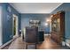 Stylish office with rich blue walls, hardwood floors, and a classic desk setup, ideal for productivity at 314 Savannah Pl, Loganville, GA 30052