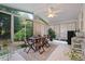 Bright and airy sunroom featuring tile floors, large windows, and a ceiling fan overlooking a lush backyard at 314 Savannah Pl, Loganville, GA 30052