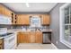 Well-lit kitchen features wood cabinets, neutral countertops, and stainless-steel dishwasher at 47 Glen Ridge Dr, Villa Rica, GA 30180