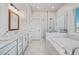 Bright bathroom features double sink vanity, a separate shower, and a soaking tub next to a window at 5217 Riden Ct # 263, Buford, GA 30518
