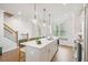 Well-lit kitchen featuring a center island, stainless steel appliances, and a staircase nearby at 5217 Riden Ct # 263, Buford, GA 30518