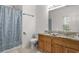 Bright bathroom features double sinks, granite counters, and blue patterned shower curtain at 747 Dill Sw Ave, Atlanta, GA 30310