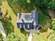 Aerial view of a home with a dark roof and a driveway with three parked vehicles at 128 Golden Hills Dr, Woodstock, GA 30189