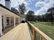 Extensive back porch with a wooden floor overlooking a lush green yard and fenced pasture at 128 Golden Hills Dr, Woodstock, GA 30189