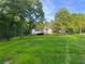 Spacious backyard with lush green grass and mature trees offering privacy at 128 Golden Hills Dr, Woodstock, GA 30189