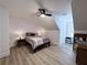 Cozy bedroom with wood floors, slanted ceiling, and a comfortable bed with bedside lamps at 128 Golden Hills Dr, Woodstock, GA 30189