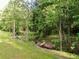 Picturesque yard with a small creek and lush greenery, creating a serene natural landscape at 128 Golden Hills Dr, Woodstock, GA 30189