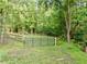 Fenced yard with lush greenery and mature trees, creating a private and tranquil space at 128 Golden Hills Dr, Woodstock, GA 30189