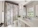 Bright bathroom featuring white marble floors, floral shower curtain, and modern fixtures at 2110 Timball Nw Rd, Atlanta, GA 30318