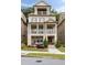 Charming three-story home with a double stacked covered porch, a brick facade, and manicured landscaping at 2110 Timball Nw Rd, Atlanta, GA 30318