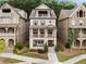 A symmetrical three-story brick home with a double covered porch and manicured lawn at 2110 Timball Nw Rd, Atlanta, GA 30318