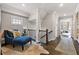Second floor hallway with hardwood floors, blue seating, and natural light at 2110 Timball Nw Rd, Atlanta, GA 30318