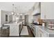 Open kitchen with island, bar stools, and stainless steel appliances seamlessly connects to dining and living areas at 2110 Timball Nw Rd, Atlanta, GA 30318
