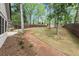 Spacious backyard featuring lush green grass, a stone pathway, and a backdrop of mature trees at 3915 Ivy Ne Rd, Atlanta, GA 30342