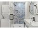 Modern bathroom with a glass shower enclosure featuring geometric tiles and sleek fixtures, plus a stacked washer dryer unit at 3915 Ivy Ne Rd, Atlanta, GA 30342