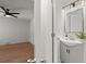 Bathroom view with gray vanity and mirror adjacent to bright, airy bedroom with hardwood floors at 3915 Ivy Ne Rd, Atlanta, GA 30342