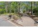 Home's driveway and manicured yard, featuring a stone wall and lush trees at 3915 Ivy Ne Rd, Atlanta, GA 30342