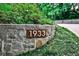 Street number on stone retaining wall with lush green landscaping along long driveway to home at 1933 Mclendon Ne Ave # A, Atlanta, GA 30307
