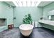 Bright bathroom with soaking tub, skylight, dual shower heads, and green tile accents at 1933 Mclendon Ne Ave # A, Atlanta, GA 30307