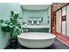 Modern bathroom featuring a soaking tub, double vanity, and green tile accents at 1933 Mclendon Ne Ave # A, Atlanta, GA 30307