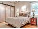 Comfortable bedroom featuring a large bed, exposed ceiling, hardwood floors, and bright natural lighting at 1933 Mclendon Ne Ave # A, Atlanta, GA 30307