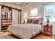 Relaxing bedroom featuring a sliding door closet, exposed ceiling, hardwood floors, and bright natural lighting at 1933 Mclendon Ne Ave # A, Atlanta, GA 30307