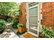 Front door to home showing the brick work and sidelight with lush green landscaping at 1933 Mclendon Ne Ave # A, Atlanta, GA 30307