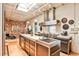 Bright kitchen with stainless steel appliances, marble counters, island, and brick wall accent at 1933 Mclendon Ne Ave # A, Atlanta, GA 30307