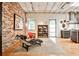 Modern living area with brick accent wall, hardwood floors, large windows, and sleek chaise lounge at 1933 Mclendon Ne Ave # A, Atlanta, GA 30307