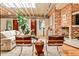 Spacious living room with exposed ceiling, hardwood floors, brick accent wall, and a cozy fireplace at 1933 Mclendon Ne Ave # A, Atlanta, GA 30307