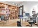 Open office area with built-in shelving, modern desk, brick wall accent, and hardwood flooring at 1933 Mclendon Ne Ave # A, Atlanta, GA 30307