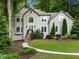 Charming two-story home featuring a manicured lawn, gray stucco, and a welcoming front entrance with manicured landscaping at 1975 River Forest Drive, Marietta, GA 30068