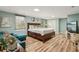 This is a bedroom featuring a cozy turquoise sofa, an entertainment center with TV, and light hardwood floors at 1977 Wee Kirk Se Rd, Atlanta, GA 30316
