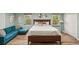 Bright bedroom with decorative wall art, a comfortable king bed, and a cozy turquoise sofa at 1977 Wee Kirk Se Rd, Atlanta, GA 30316