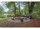 Backyard fire pit area with stone benches and mature trees, ideal for outdoor entertaining at 1977 Wee Kirk Se Rd, Atlanta, GA 30316