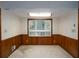 Formal dining room with wood paneling and view of the lush, landscaped backyard through a large picture window at 4135 Sunrise Trail, Atlanta, GA 30349