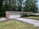 A charming single-story home features a stone accent wall, attached garage and long driveway with a lush, green yard at 4135 Sunrise Trail, Atlanta, GA 30349
