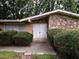 Charming front entrance with a double door framed by stone accents and manicured bushes; warm lighting invites guests at 4135 Sunrise Trail, Atlanta, GA 30349