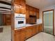 Classic eat-in kitchen with wood cabinets, built in oven, and a view into a separate eating area at 4135 Sunrise Trail, Atlanta, GA 30349
