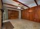 Spacious living room with wood-paneled walls, brick fireplace, exposed beams, and a ceiling fan for added comfort at 4135 Sunrise Trail, Atlanta, GA 30349