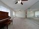 Bright living room with a piano, large mirror wall, neutral carpet, and a ceiling fan for comfort, perfect for entertaining at 4135 Sunrise Trail, Atlanta, GA 30349