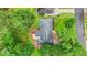 An aerial view shows the house, its roof, deck, driveway, and surrounding lush trees at 4188 Fontana Ct, Tucker, GA 30084