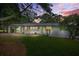 Charming single-story home with white exterior, green door, and a well-manicured lawn at dusk at 4188 Fontana Ct, Tucker, GA 30084