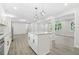Bright open kitchen features white cabinets, sleek granite countertops, an island and a view to the living area at 4188 Fontana Ct, Tucker, GA 30084